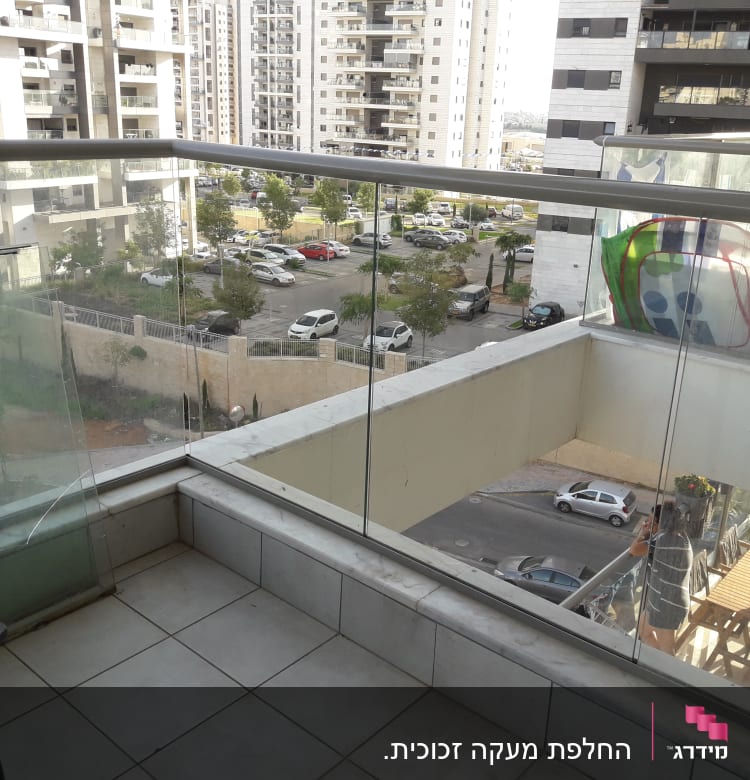 מעקה זכוכית במרפסת עם נוף עירוני